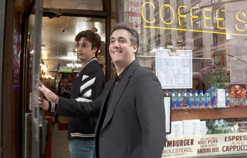 In this image taken from video Michael Cohen, right, President Donald Trump's former lawyer, and his son Jake step into a coffee shop, Saturday, May 4, 2019, in New York. Cohen is scheduled to report on Monday, May 6, to a federal prison 70 miles north of New York City to begin serving a three-year sentence for campaign-finance violations, tax evasion, bank fraud and lying to Congress. (AP Photo/Aron Ranen)