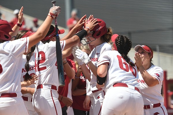 The Arkansas squad congratulates Danielle Gibson on her home run in the fifth inning against Auburn Sunday May 5, 2019 at Bogle Park in Fayetteville. The Razorbacks won 5-2.