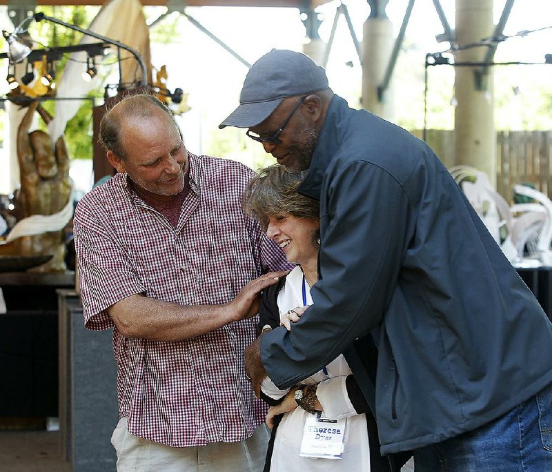 Theresa Dyer (center) of Nashville, Tenn., is congratulated by fellow finalists Charles Strain (left) of Harrisburg, Mo., and Nnamdi Okonkwo (right) of Atlanta after Dyer was named the winner of the $60,000 public art commission during the 11th Sculpture at the River Market Show on Sunday in Little Rock. 