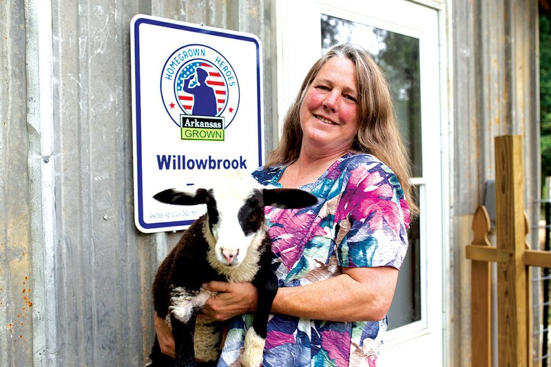 Jan Farmer holds a lamb at Willowbrook Farm. Farmer sells lamb meat and cheese in farmers markets, including the Searcy Certified Farmers Market, and said she hopes people understand and value the work farmers do for their craft.