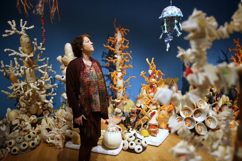 Angela Haseltine Pozzi, creator of the Washed Ashore project, pauses in a coral reef made of trash, the first walk-through reef exhibit by the project. The exhibit, which illustrates the magnitude of ocean pollution, is on display at the Clinton Presidential Center. Photo by Thomas Metthe, Arkansas Democrat-Gazette