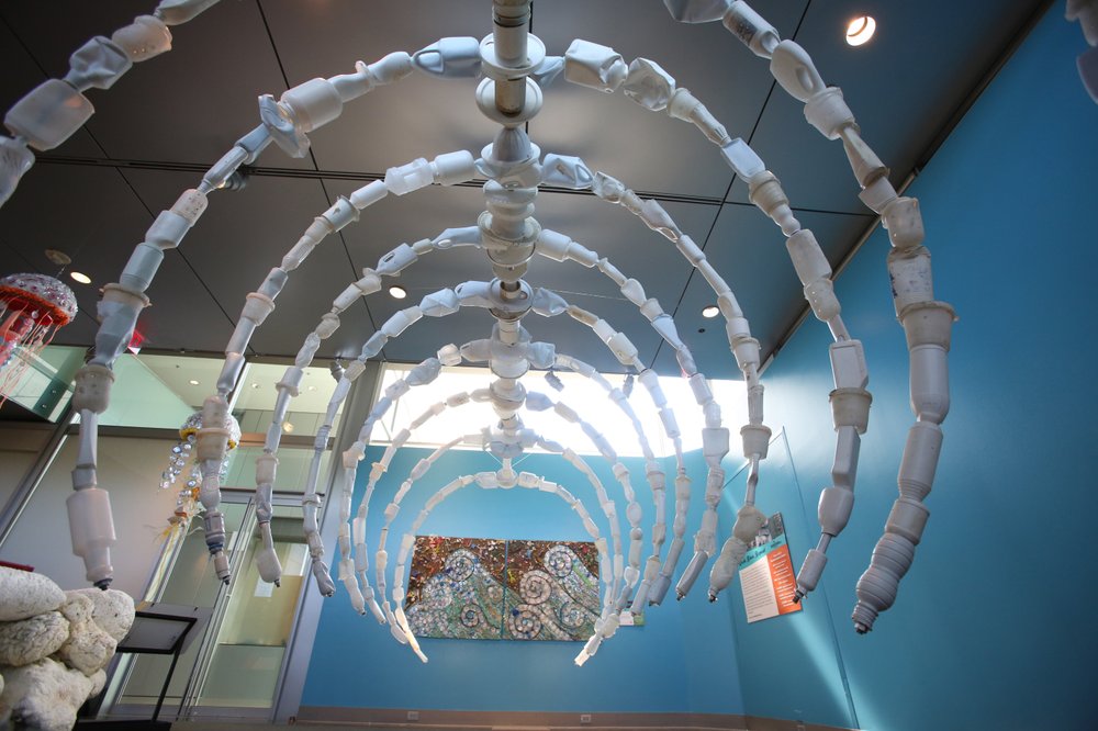 A giant whale rib cage made of white plastic jugs gives visitors an idea of just how large the creatures are in “Washed Ashore: Art to Save the Sea” at the Clinton Presidential Center. Photo by Thomas Metthe, Arkansas Democrat-Gazette