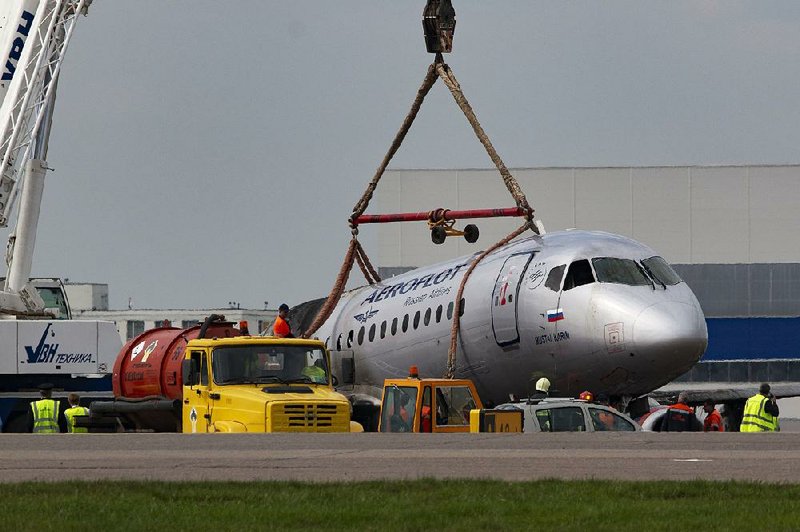 A crane lifts the damaged Sukhoi SSJ100 aircraft of Aeroflot Airlines at Sheremetyevo airport, outside Moscow, on Monday. 