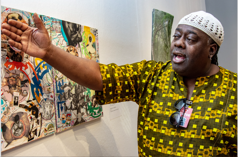 Kevin Cole, juror for the Arkansas Arts Center’s “61st Annual Delta Exhibition” talks about the elements in Scinthya Edwards’ diptych collage, "Birds of a Feather," which won a Delta Award. (​​​​​Arkansas Democrat-Gazette/CARY JENKINS)
