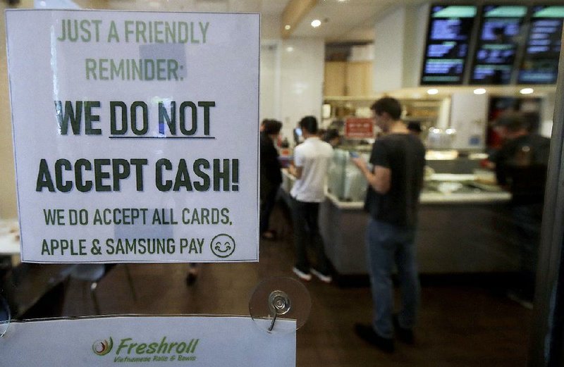 A sign posted Thursday at Freshroll Vietnamese Rolls and Bowls in San Francisco alerts customers that it does not accept money as payment for its food. 