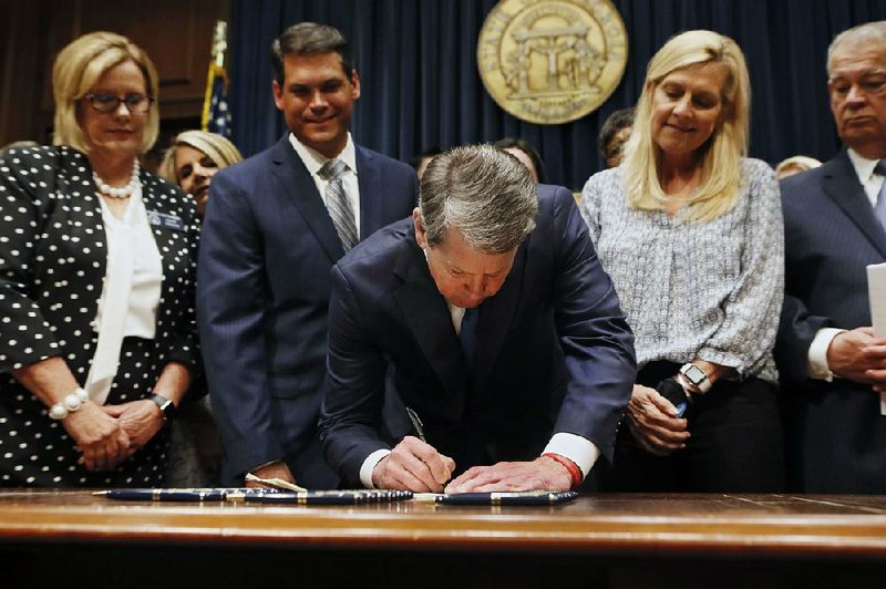 Georgia Gov. Brian Kemp signs legislation Tuesday in Atlanta banning abortions once a fetal heartbeat can be detected, which can be as early as six weeks, before many women know they’re pregnant. 