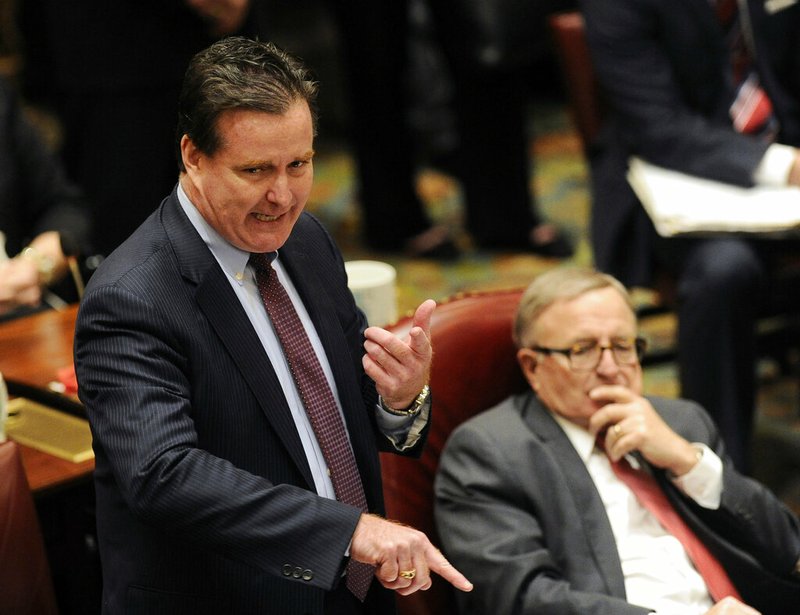 In this Jan. 4, 2017 file photo, New York State Senate Majority Leader John Flanagan, R-Smithtown, left, speaks to members in the Senate Chamber at the Capitol on the opening day of the legislative session in Albany, N.Y. Calling it a "blatant political act," Flanagan, now the leader of the chamber's Republican minority, opposes the bill that would allow congressional investigators to get access to President Donald Trump's state tax returns. The bill is up for a vote on Wednesday, May 8, 2019. (AP Photo/Hans Pennink, File)