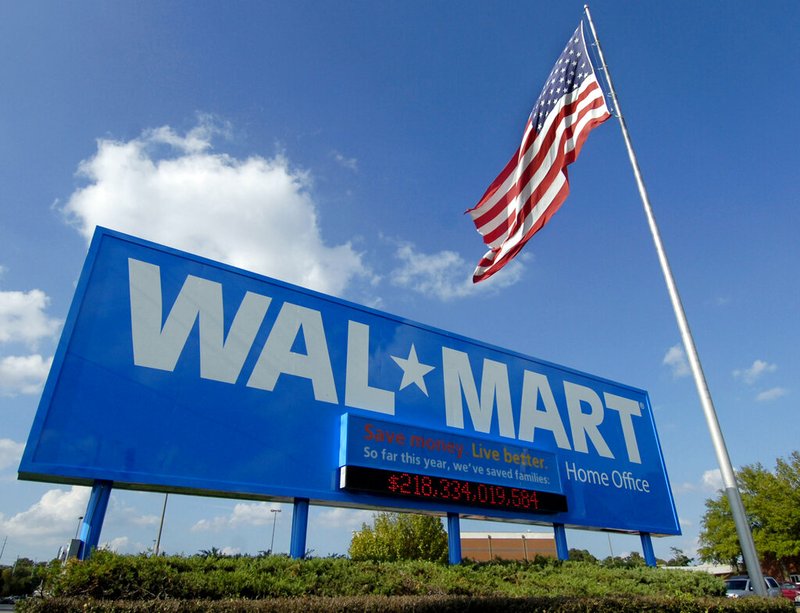 In this Oct. 5, 2007, file photo, an American flag flies in front of the Walmart Stores Inc. headquarters in Bentonville, Ark. Walmart said Wednesday, May 8, 2019, that it will raise the minimum age for tobacco products and e-cigarettes to 21 in an effort to combat tobacco sales to minors. The world’s largest retailer says the new rule will take effect in July, and will also include its Sam’s Club warehouse stores. (AP Photo/April L. Brown, File)