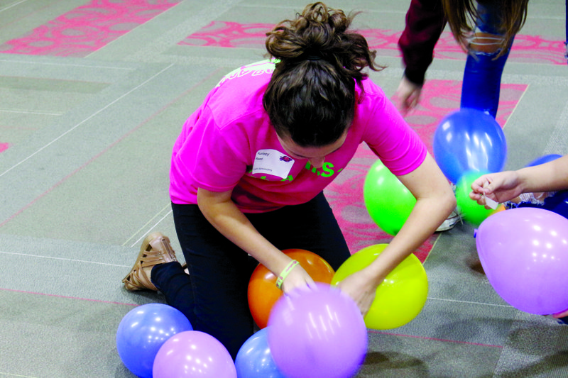 Tower: Eighth grader Kelsey Reed works on building a tower out of balloons and tape along with her teammates. Michael Shine/News-Times