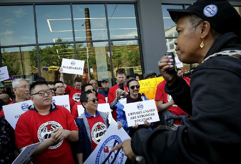 Michelle Dottin, a driver with the Independent Drivers Union Guild, speaks at a drivers’ protest rally Wednesday outside Uber and Lyft offices in New York. 