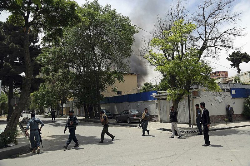 Afghan security forces take position Wednesday in Kabul near the site of a Taliban attack on the offices of the U.S.-based aid organization Counterpart International. 