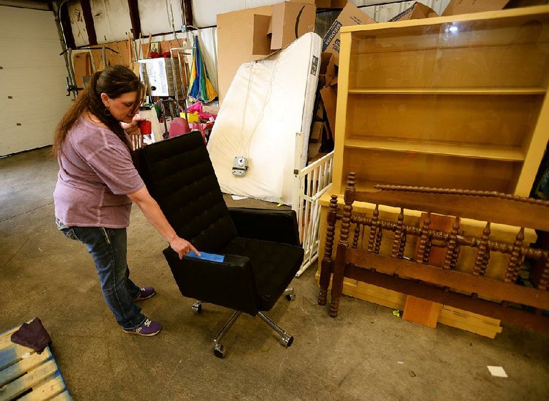 Terri Rutherford of the Salvation Army Thrift Store in Fayetteville rolls out a chair from the set for the apartment of Wayne Hays, the lead character in True Detective. Hays, an Arkansas State Police detective, was played by actor Mahershala Ali. More photos are available at arkansasonline.com/59truedetective 