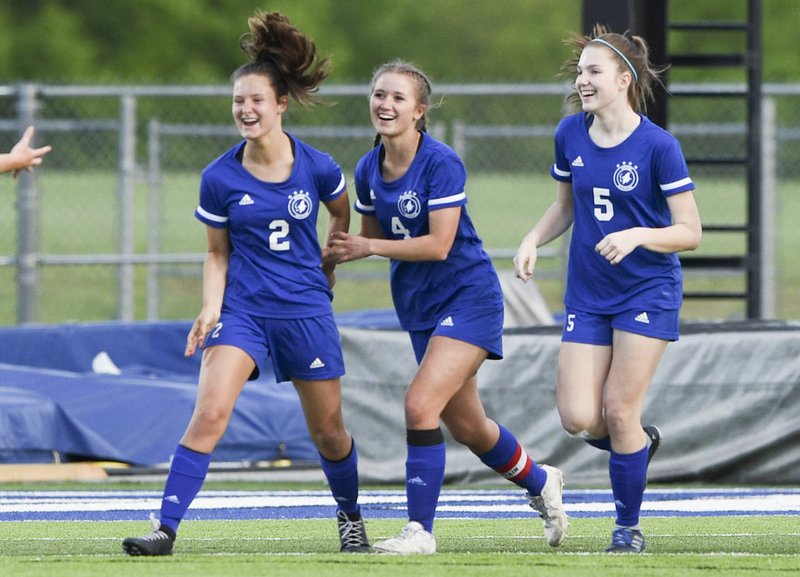 NWA Democrat-Gazette/CHARLIE KAIJO Rogers High's Haley Arrick (center) celebrates with teammates following a goal during a match earlier this season. She has seen her role change this season, after helping the Lady Mountis claim a state title last year.