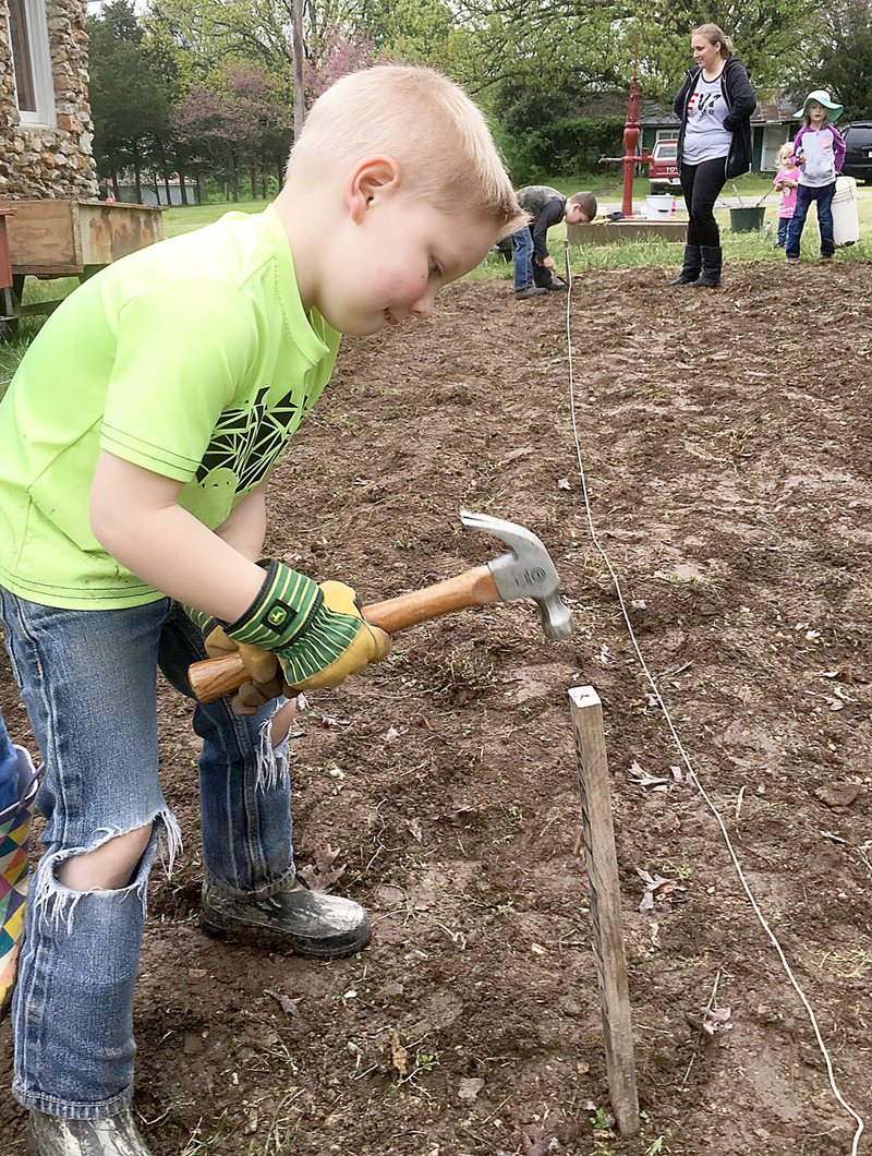 Courtesy photo Abram Abernathy hammers a stake in the New Bethel &quot;Victory Garden&quot; by the New Bethel School near Anderson. Abernathy is part of two home-school families who are working with organizer Karen Almeter to hoe, stake, pick rocks and plant the vegetable garden. Almeter decided to call the effort a &#x201c;Victory Garden,&#x201d; which was part of a World War II campaign to feed the populace and the soldiers. Those who attend Saturday&#x2019;s New Bethel Heritage Festival will have the chance to enjoy the beginnings of the garden, along with various demonstrations, hand-crafted items for sale and a lunch by donation. Admission is free. All proceeds from the festival will help fund the schoolhouse's preservation.