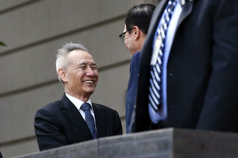 Chinese Vice Premier Liu He (left) and U.S. Treasury Secretary Steve Mnuchin exchange greetings Thursday outside the U.S. trade representative’s office in Washington before the start of their talks. 