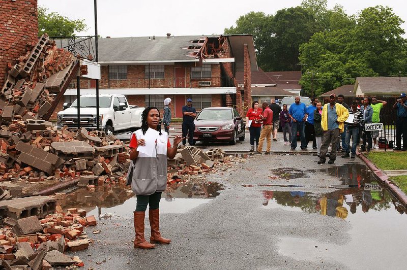 Michelle Corbin (left) instructs residents of Myranda’s Place Apartments on how to sign up for assistance from the American Red Cross and other agencies after Wednesday night’s tornado in Pine Bluff. 