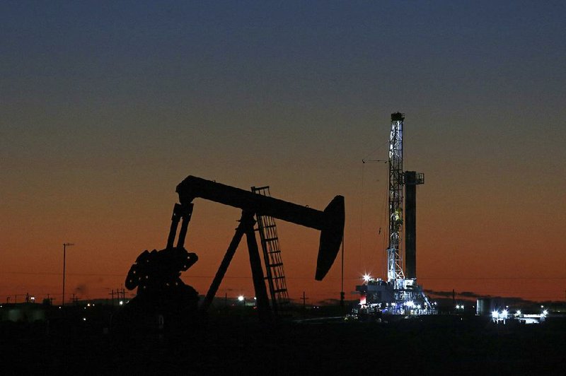 An oil rig and pump jack are pictured in Midland, Texas. 