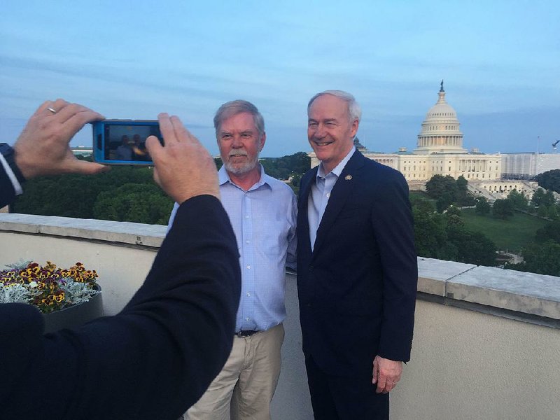 State Rep. Dan Douglas (left), R-Bentonville, poses with Gov. Asa Hutchinson at the Arkansas State Chamber of Commerce’s congressional reception Thursday on a rooftop overlooking the U.S. Capitol.