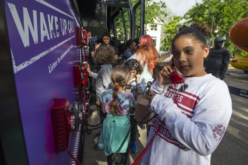 Madison Osbon, 10, of Bentonville listens to a recording Friday, May 10, 2019, at the Inclusion Town area at Compton Gardens during the Bentonville Film Festival. The phones are part of the Check Your Blind Spots Tour presented by CEO Action for Diversity & Inclusion. The tour presented a variety of interactive experiences designed to help guests learn about unconcious bias they may hold.