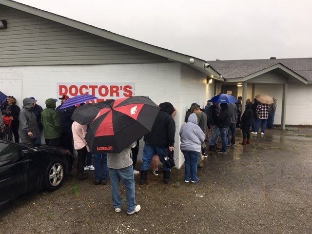 A line of people stand in the rain outside Doctors Orders RX on U.S. 270 east of Hot Springs on Saturday. The dispensary became the first medical marijuana dispensary to serve a patient in Arkansas on Friday, albeit to test software. 