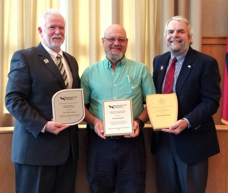 Sierra Bush/Siloam Sunday City Administrator Phillip Patterson, right, and Mayor John Turner, left, pose with wastewater superintendent Tom Myers, center, after recognizing him and the Siloam Springs Water/Wastewater Department Tuesday for winning state and national awards in safety and excellence.