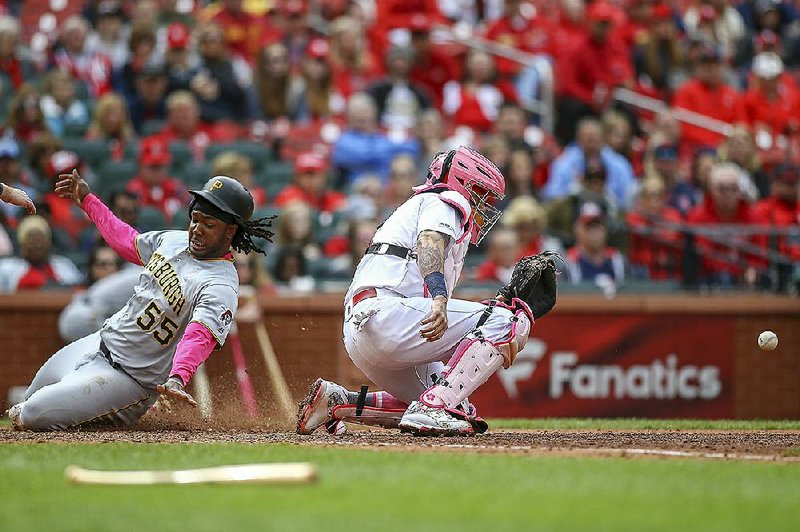 Josh Bell slides into home for Pittsburgh as St. Louis Cardinals catcher Yadier Molina waits for the ball during the eighth inning Sunday in St. Louis. Bell went 4 for 4 and drove in a career-high 5 runs to lead the Pirates to a 10-6 victory.