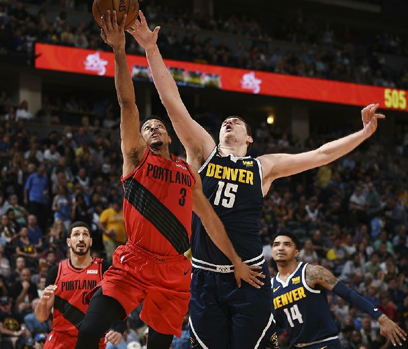 Portland Trail Blazers guard CJ McCollum drives to the rim past Denver Nuggets center Nikola Jokic in the second half of Game 7 of their Western Conference semifinal playoff series Sunday in Denver. McCollum scored 37 points as the Trail Blazers won 100-96 to win the series 4-3.
