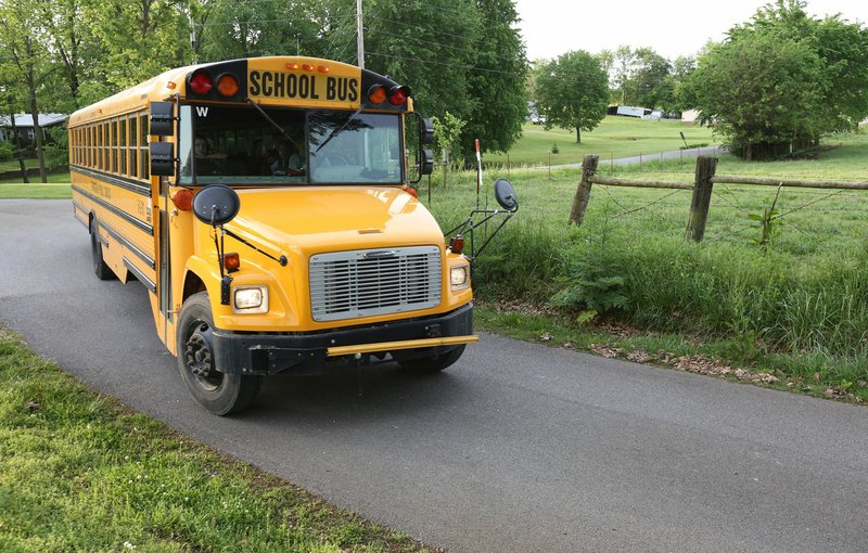 NWA Democrat-Gazette/DAVID GOTTSCHALK A Farmington Public Schools bus turns Tuesday, May 7, 2019, onto Gibson Hill Road from Wesley Stevens Road. Washington County is working with local school districts to identify and improve some of the narrow, dangerous county roads that double as bus routes.