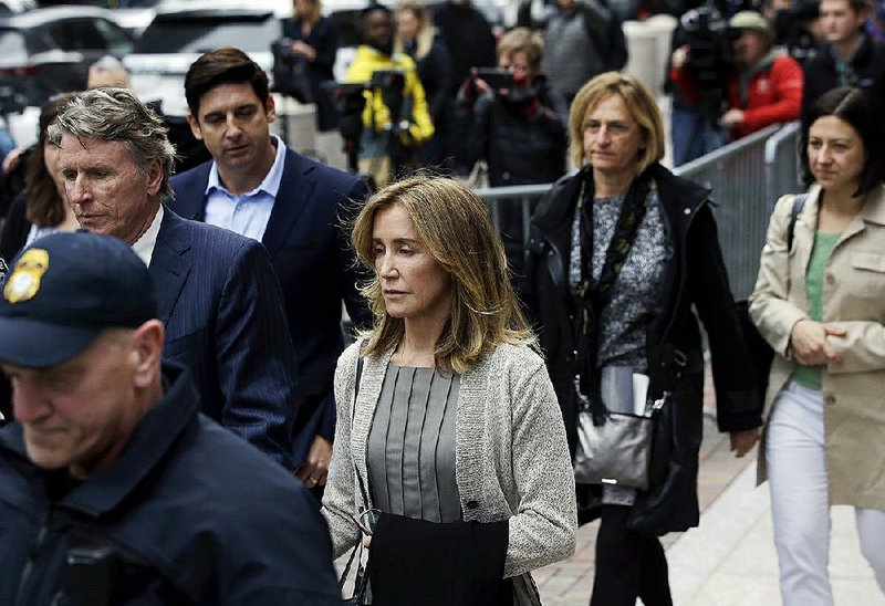 Felicity Huffman (center) departs federal court with her brother Moore Huffman Jr. (left) on Monday, in Boston, where she pleaded to charges in a nationwide college admissions bribery scandal. 