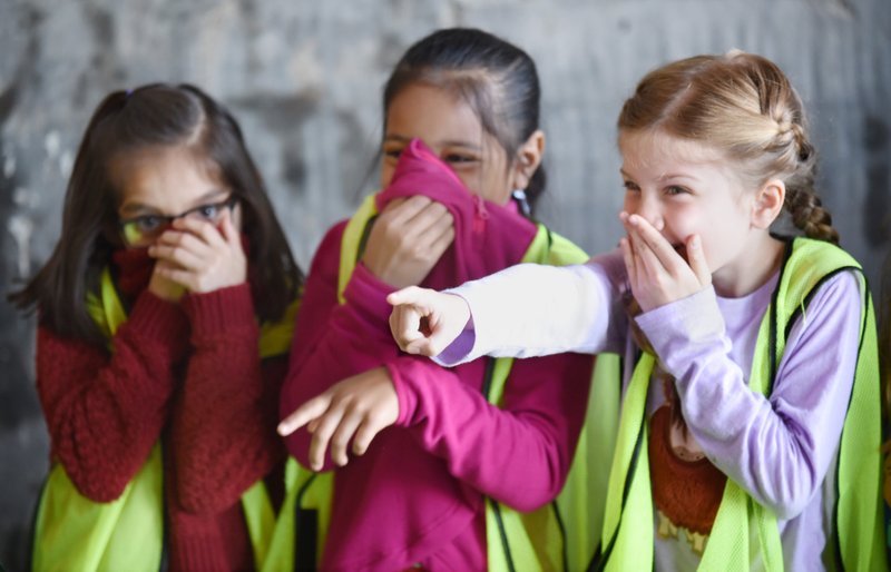 Clara Culpepper (right), a second grade student in Chad Lechtenberger's class at Washington Elementary School, covers her nose Monday, May 13, 2019, with classmates as they stand in the Transfer Station during a tour in Fayetteville. The students toured the city of Fayetteville Transfer Station and Material Recovery Facility as part of unit studying natural resources and recycling environmental issues. NWA Democrat-Gazette/DAVID GOTTSCHALK