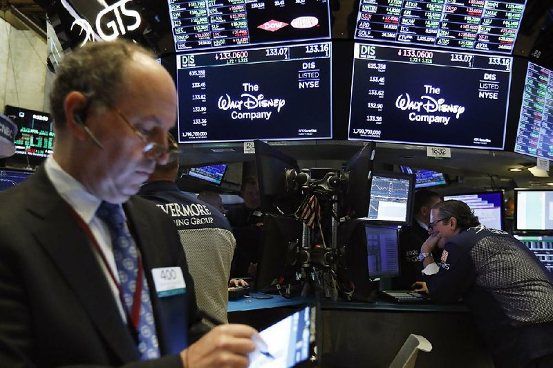 The logo for the Walt Disney Co. appears Tuesday above trading posts on the floor of the New York Stock Exchange as Disney struck a deal with Comcast over its stake in Hulu. Tuesday’s stock recovery took place after another round of morning tweets from President Donald Trump regarding a Chinese trade deal. 