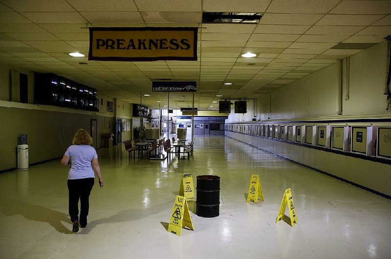 A barrel catches water from a section of leaking ceiling at Pimlico Race Course in Baltimore, site of Saturday’s Preakness. The future of Pimlico has turned into a tug of war involving city officials, who want it to stay in Baltimore, and the owners of the track, who long to move the second jewel of the Triple Crown to nearby Laurel Park. 