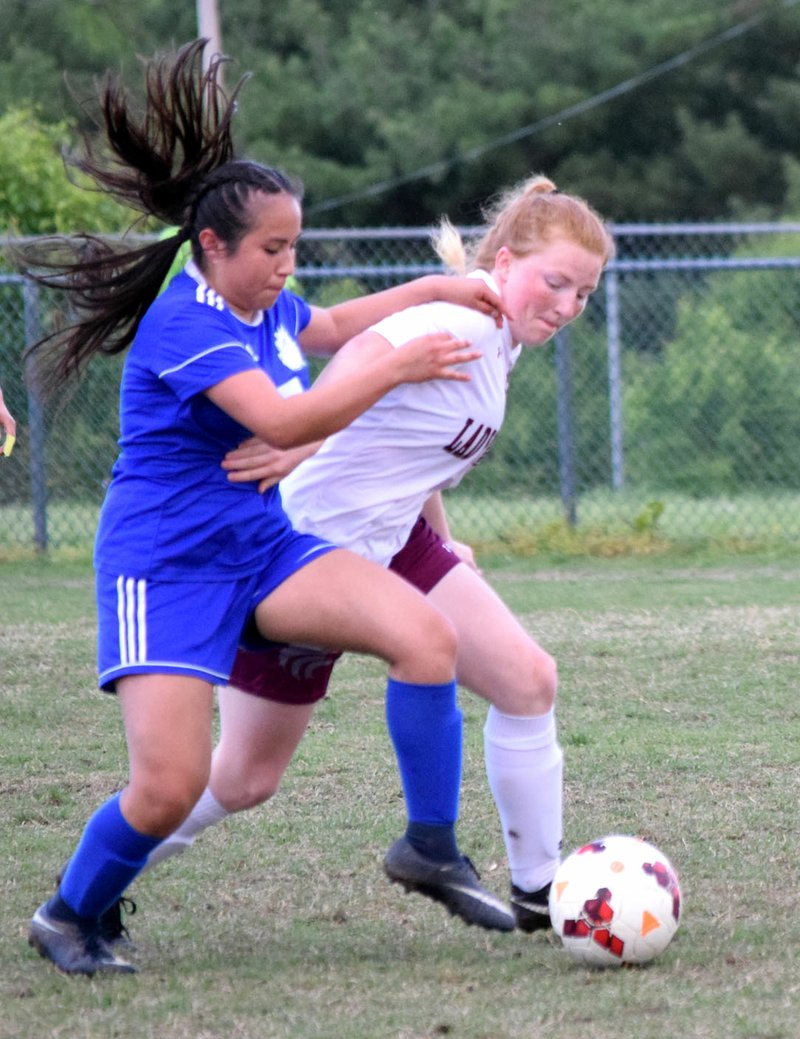Westside Eagle Observer/MIKE ECKELS Decatur's Dania Uribe (left) and Lincoln's Odessa Stanley fight for control of a loose ball during the April 25 Decatur-Lincoln varsity girls soccer match in Decatur.