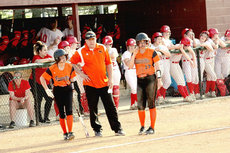 MARK HUMPHREY ENTERPRISE-LEADER Gravette softball coach Taos Jones talks to a pair of base runners, senior Sumer Kaba (left) and sophomore Taylor Snow, during a break in the action with the Farmington dugout behind him. Long-time rivals, Farmington and Gravette, renewed conference and classification competition this season with the Lady Cardinals rejoining the 4A-1 after five seasons as a member of the 5A West. After battling in the District 4A-1 and 4A North Regional championships, a much anticipated showdown between the teams at state didn't materialize with the Lady Lions losing 2-0 to Brookland in the quarterfinals.