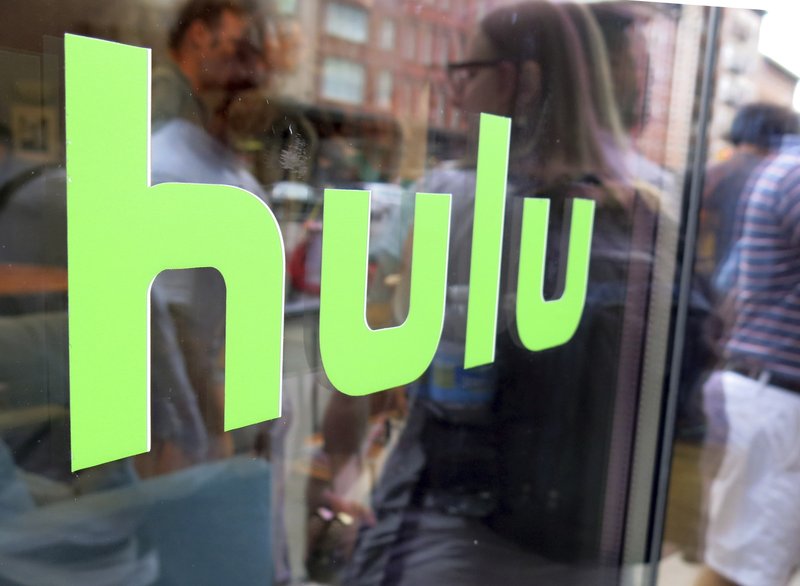 This June 27, 2015, file photo, shows the Hulu logo on a window at the Milk Studios space in New York. Disney has struck a deal with Comcast that gives it full control of streaming service Hulu.(AP Photo/Dan Goodman, File)