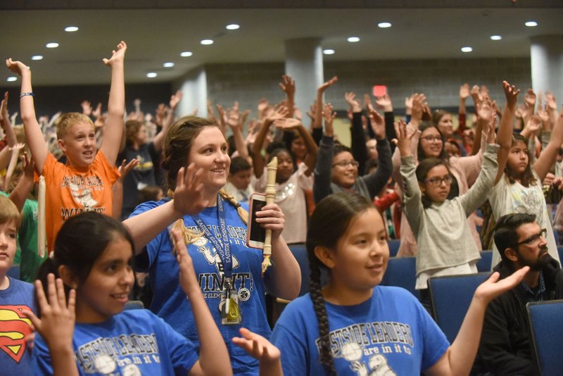 Jordan Cox, a teacher at Eastside Elementary in Rogers, dances with students Wednesday May 15 2019 to a tune played by the Arkansas Philharmonic Orchestra during an orchestra program at Rogers High School auditorium. Fourth and fifth grade students in the Rogers school district took part in the orchestra's "Link Up, the Orchestra Moves" program run by the Carnegie Hall Foundation. District teachers sang and played along with the orchestra and led students in dancing and playing their soprano recorders. Students start to learn the recorder in third grade, said Daniel Abrahams, a professor at the University of Arkansas who is involved with the program.