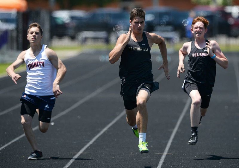 Brock McRae of Bentonville (center) leads Zach Woods of Pea Ridge (right) and Evan Miller of Trinity Christian (left) on Wednesday while competing in the 100-meter portion of the state high school decathlon championship at Ramay Junior High School in Fayetteville. 