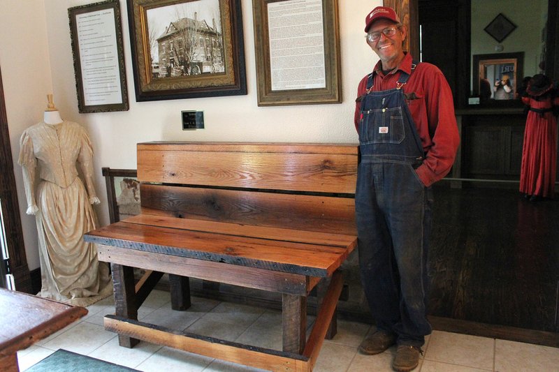 MEGAN DAVIS/MCDONALD COUNTY PRESS Jimmie Gideon stands next to a bench he built and donated to the McDonald County Historical Museum. The wood was reclaimed from the historic Puckett School in the county.