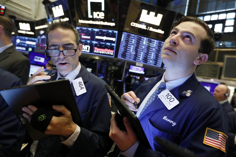 In this May 9, 2019, file photo traders Gregory Rowe and Benjamin Tuchman work on the floor of the New York Stock Exchange.  (AP Photo/Richard Drew, File)