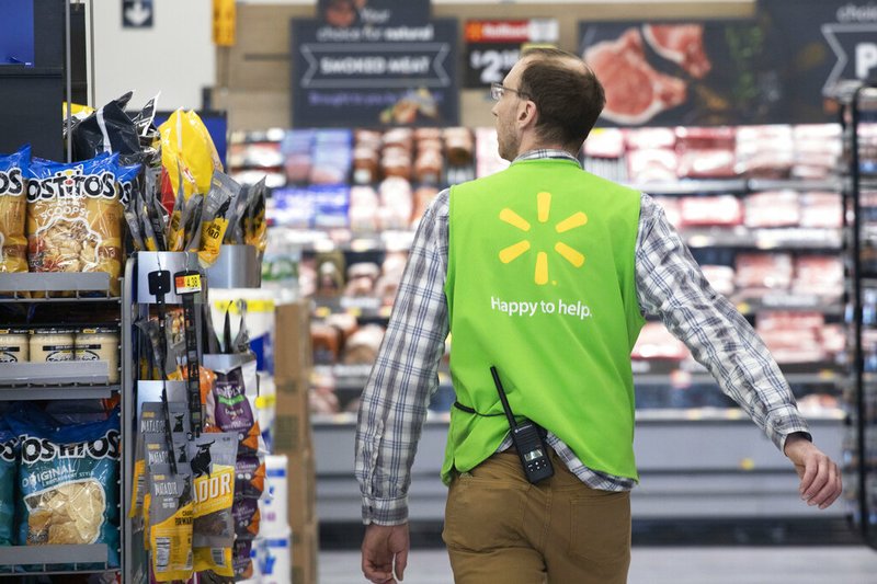 In this April 24, 2019, file photo a Walmart associate works at a Walmart Neighborhood Market in Levittown, N.Y. Walmart Inc. reports earnings on Thursday, May 16. (AP Photo/Mark Lennihan, File)