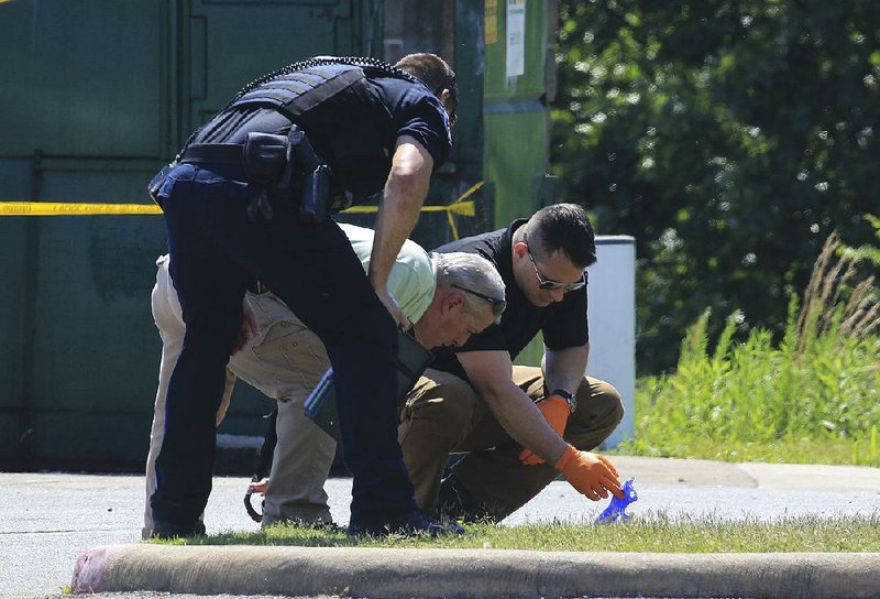 North Little Rock Police gather evidence Thursday at the scene of a homicide at the Wilmington Apartments on Donovan Briley Boulevard. 