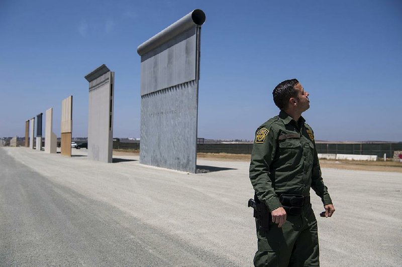 Border Patrol Public Affairs Officer Vincent Pirro observes prototype border wall samples in San Diego in April of 2018. A hearing today on the means to fund wall construction is the first of likely many challenges to the plan. 