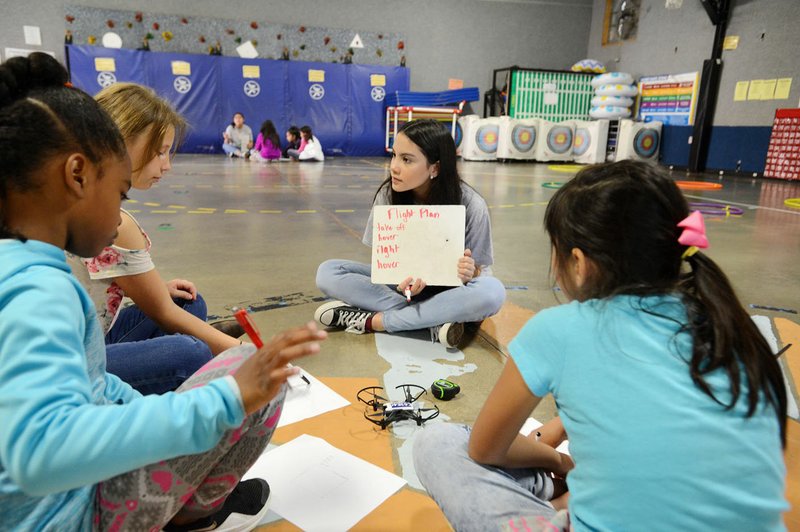 NWA Democrat-Gazette/SPENCER TIREY Madelyn Xaysanasy, a student at Don Tyson School of Innovation, teaches girls at Parson Hills Elementary how to program a drone Thursday. Female students at Tyson School of Innovation have been mentoring female elementary students how to program drones. Their initial goal was to work with 300 students but at Parson Hills they will top more than 1,000 students.