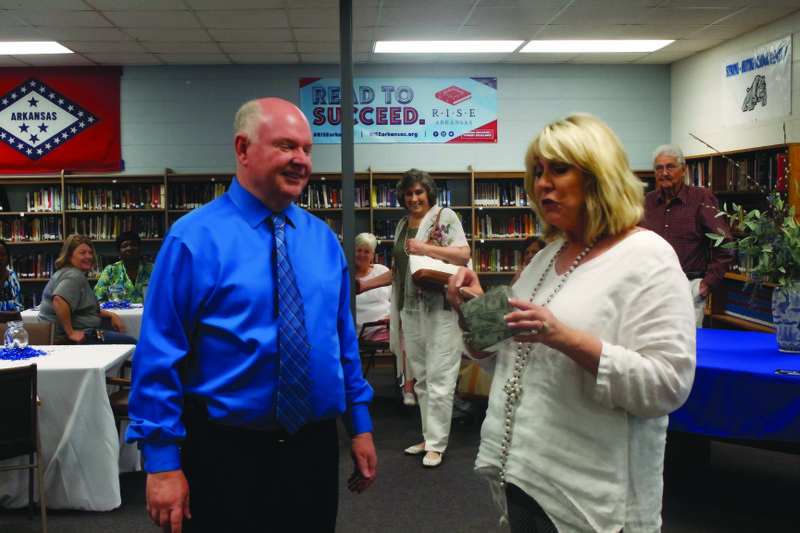 Becky Bolding, Gardner-Strong Elementary school improvement specialist gives outgoing Superintendent Jeff Alphin a “money machine” the district came together to give to him at the retirement party held for Alphin on Thursday afternoon. Michael Shine/News-Times