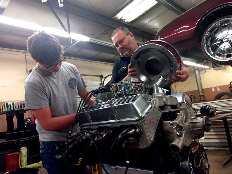 Garrett Birmingham, 17, left, of Sylvan Hills High School in Sherwood, disassembles portions of a truck engine with Jacksonville High School shop teacher Wayne Griffin. Birmingham is on the team that disassembles and reassembles engines for competition against other students nationally.