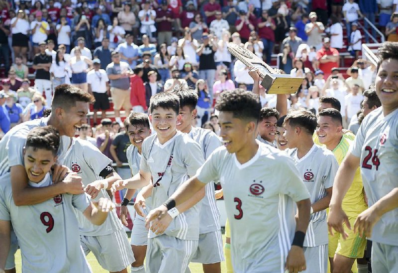 Springdale players react after defeating Bryant 3-0 in the Class 6A boys soccer state championship Friday at Razorback Field in Fayetteville.