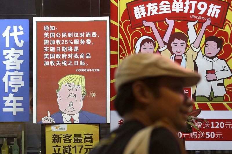 A poster outside a restaurant in China’s Guangdong province depicts President Donald Trump and warns that American customers will be charged 25% more than others. 