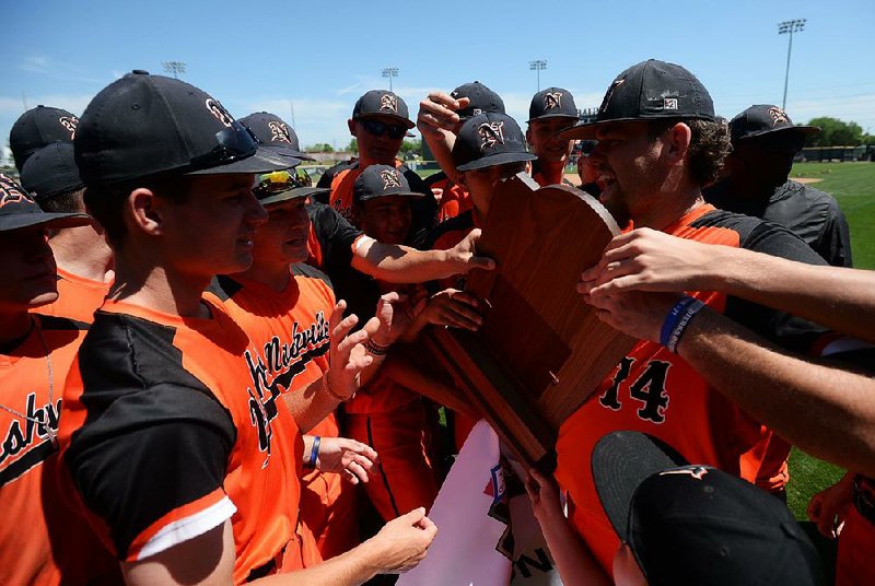 Nashville players take turns touching the state championship trophy Friday after the Scrappers defeated Shiloh Christian 1-0 for the Class 4A state title at Baum-Walker Stadium in Fayetteville. Nashville won its third consecutive state championship thanks to a solo home run from senior second baseman Jaydon Hostetler.