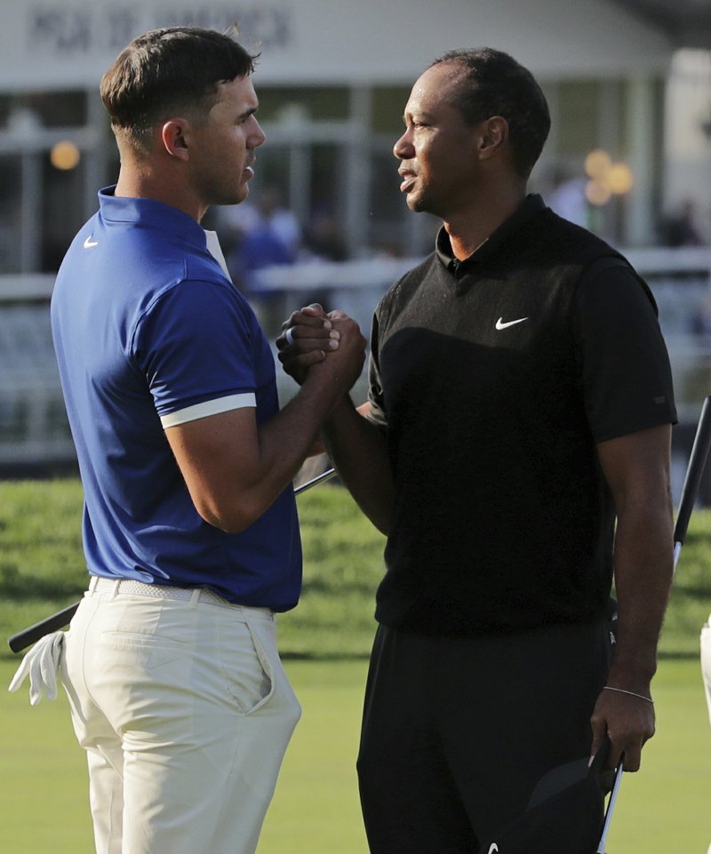 Brooks Koepka, left, shakes hands with Tiger Woods after finishing the second round of the PGA Championship golf tournament, Friday, May 17, 2019, at Bethpage Black in Farmingdale, N.Y. (AP Photo/Charles Krupa)