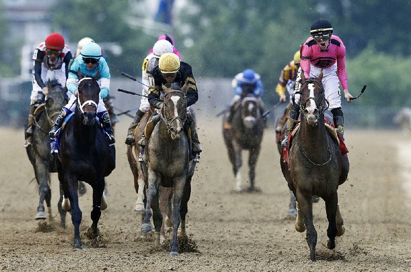 Jockey Tyler Gaffalione (right) reacts aboard War of Will as they cross the finish line to win the Preakness Stakes on Saturday at Pimlico Race Course in Baltimore. Everfast (center), ridden by Joel Rosario, was second.